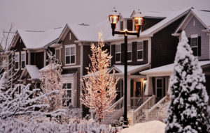 Snow- covered townhouses at dusk.