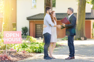 Real estate agent welcoming young visitors of open house for sale